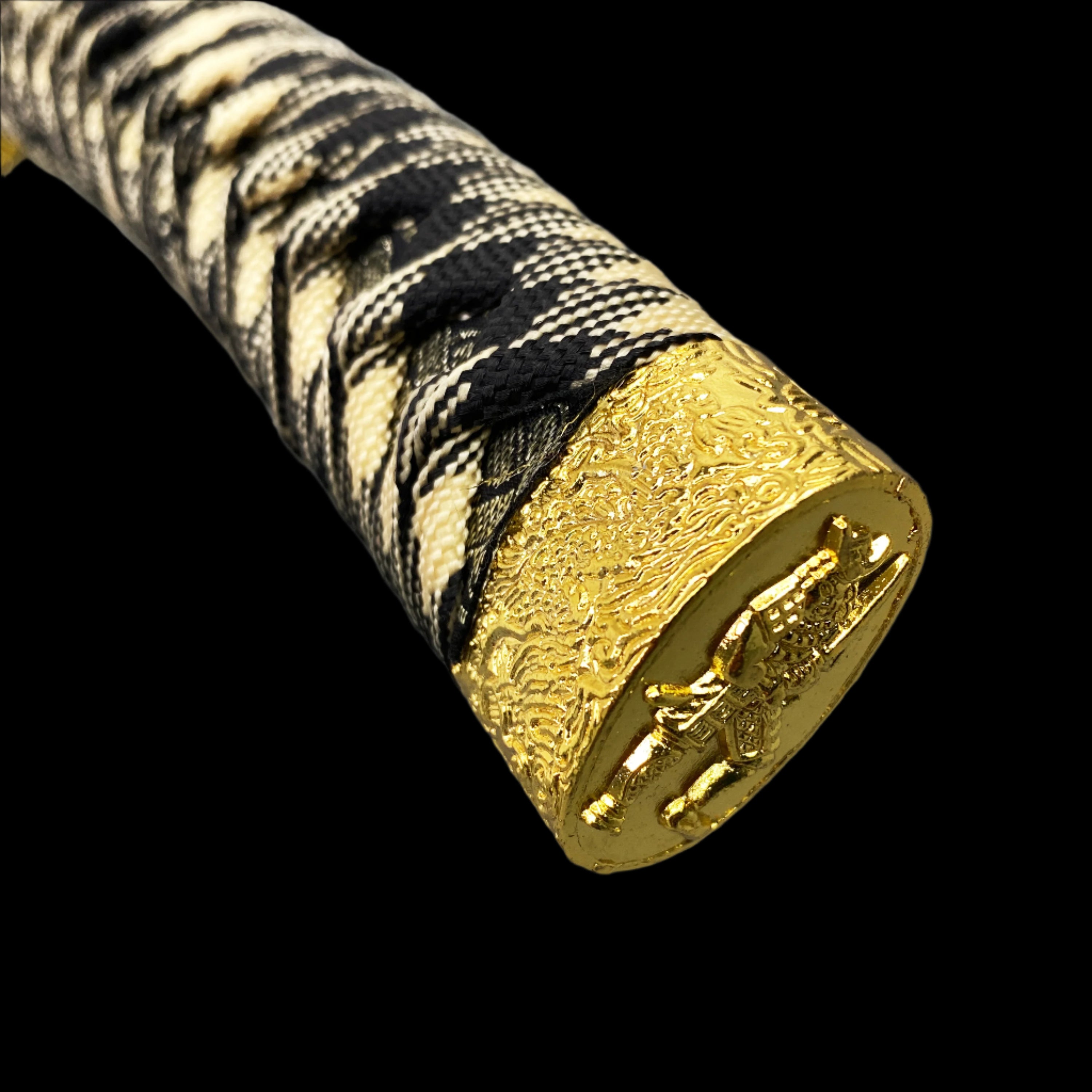 Gold and black patterned sword handle on a gray background