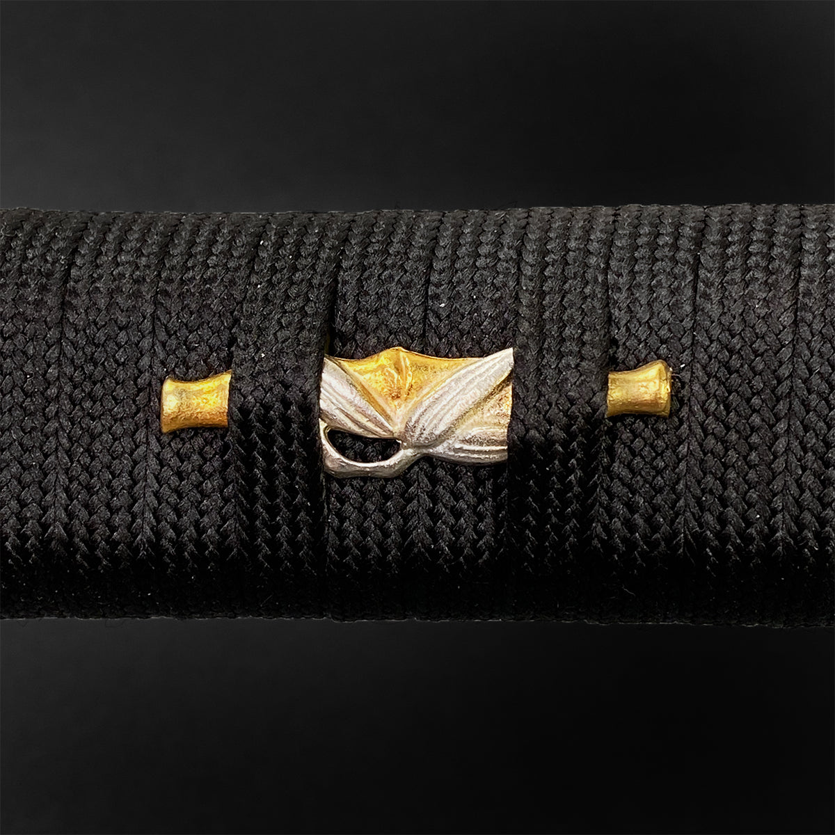 Detailed close-up of the handle of a Wholesale Musashi Samurai Sword Katana with intricate tsuba design